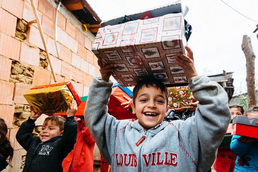 Ein Junge aus Rumänien freut sich über sein Schuhkartongeschenk. (Foto: David Vogt)