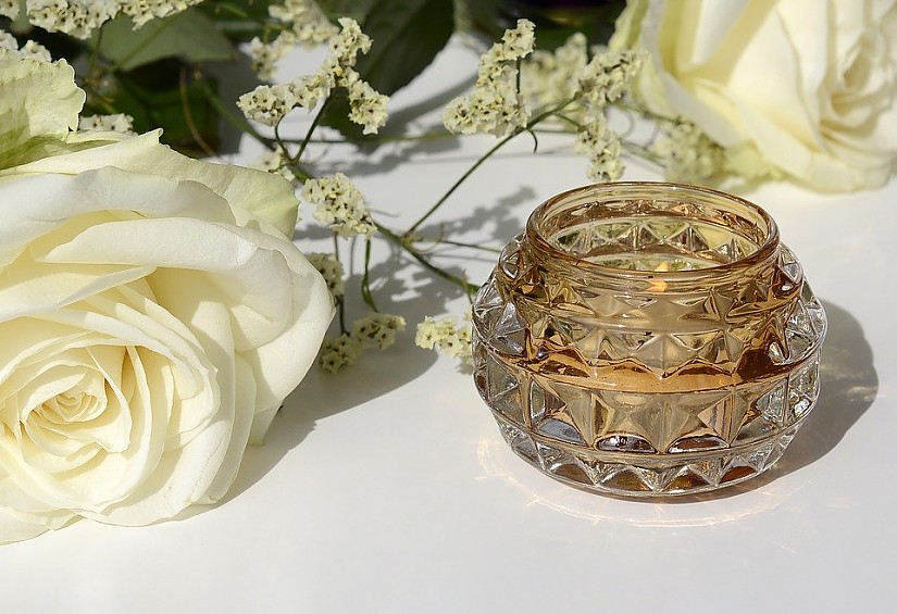 Symbolbild Kerze und Blumen Quelle Pixabay.