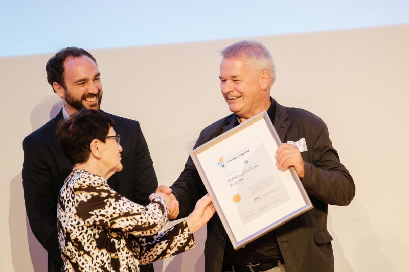 DVV-Ehrenpräsidentin Rita Süssmuth überreichte Urkunde und Skulptur an Ulrich Dillmann von der vhs Weimar. Im Hintergrund Marvin Schnell vom Goethe-Institut Rom. (Foto:  © Sandrino Donnhauser)